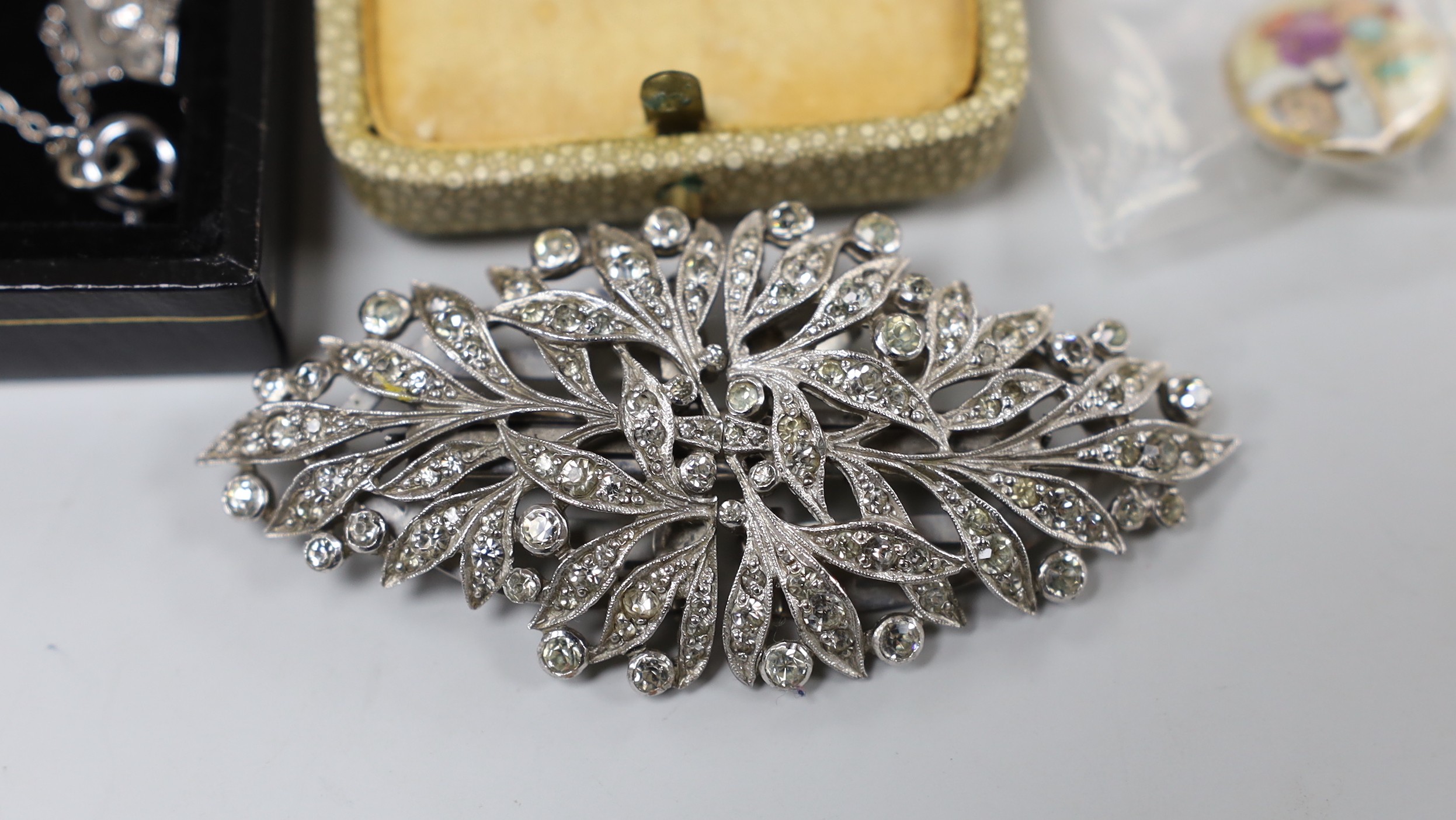 A small group of white metal and paste set jewellery, including a double clip brooch, necklace and three pairs of earrings, three satsuma buttons and a cloisonne ring.